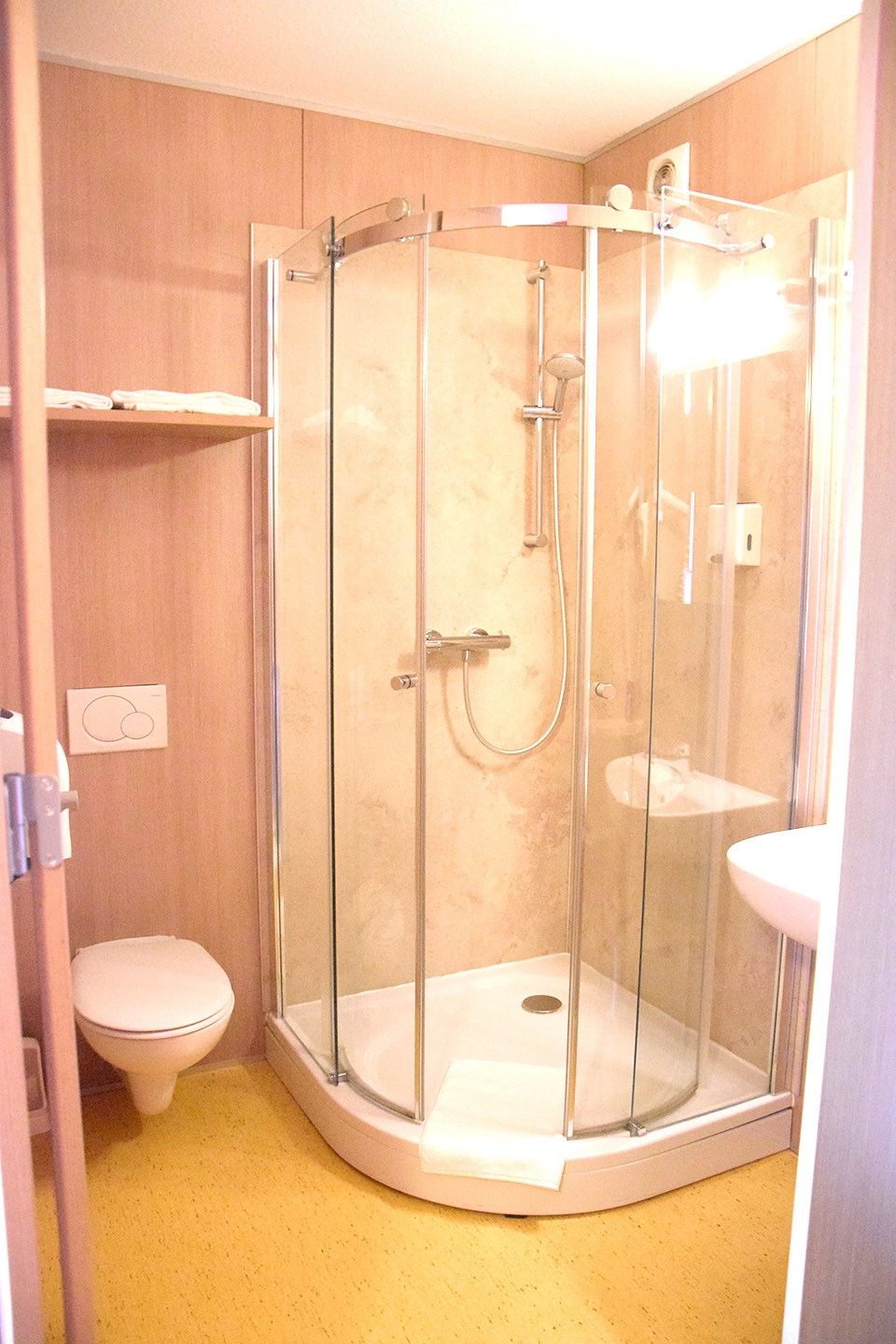 Malá kúpeľňa so sprchovacím kútom, WC a umývadlom.