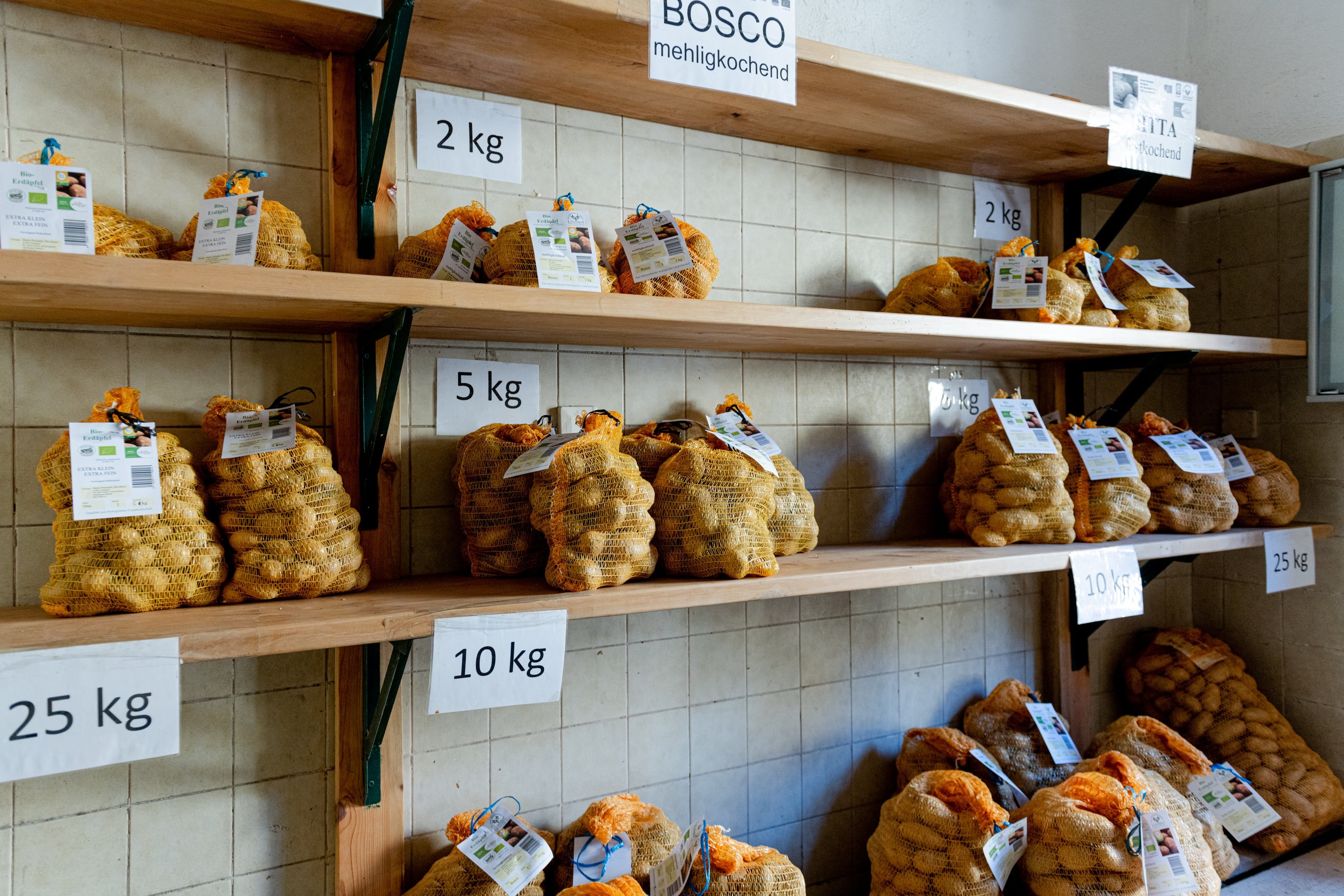 Predajná miestnosť s regálmi s vrecami na zemiaky v rôznych hmotnostných jednotkách.