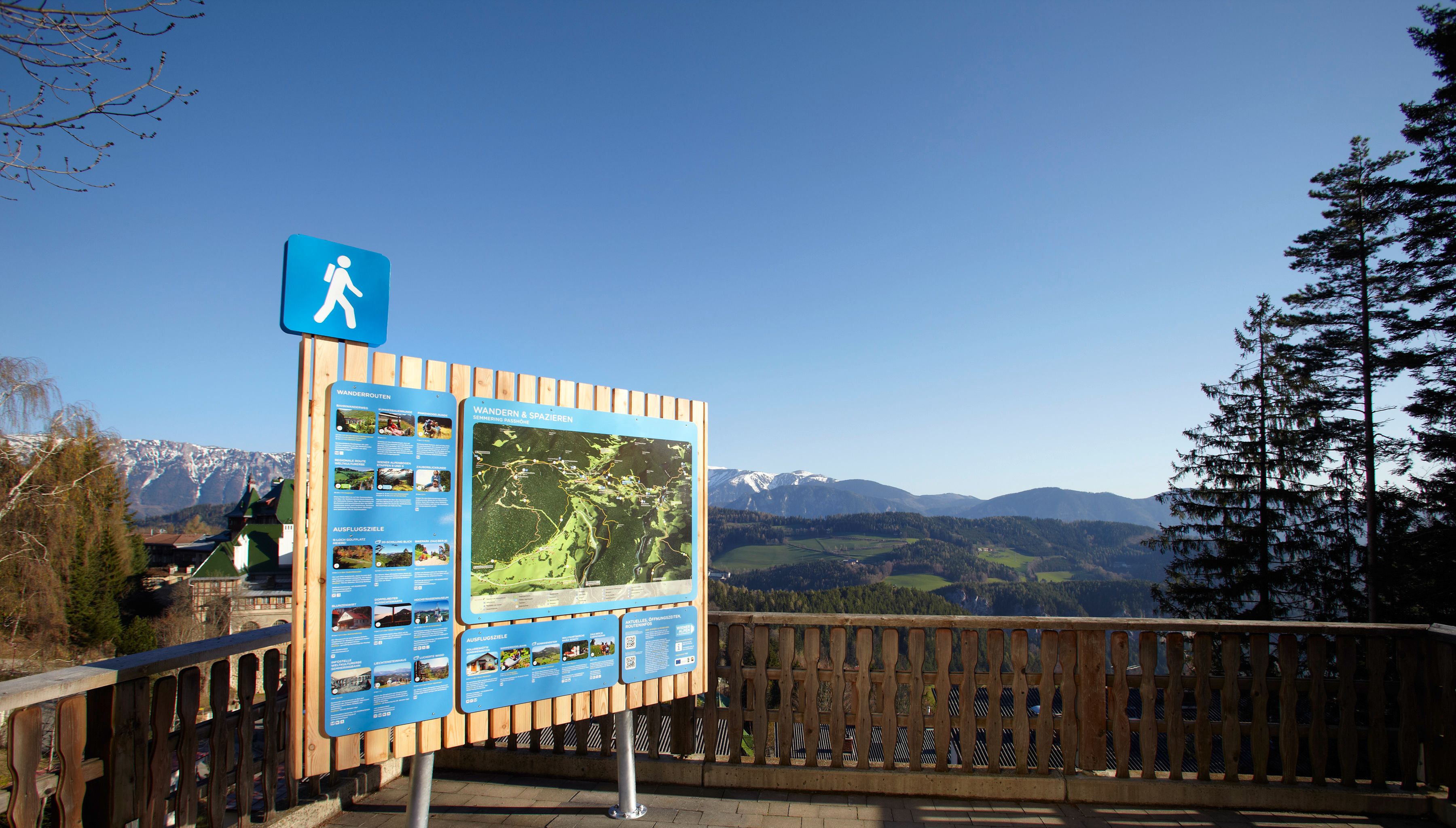 Východiskový bod turistiky Semmering s informačnou tabuľou a horskou krajinou v pozadí.