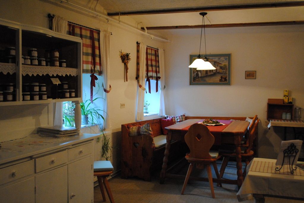 Útulná kuchyňa s dreveným nábytkom a kockovanými závesmi.