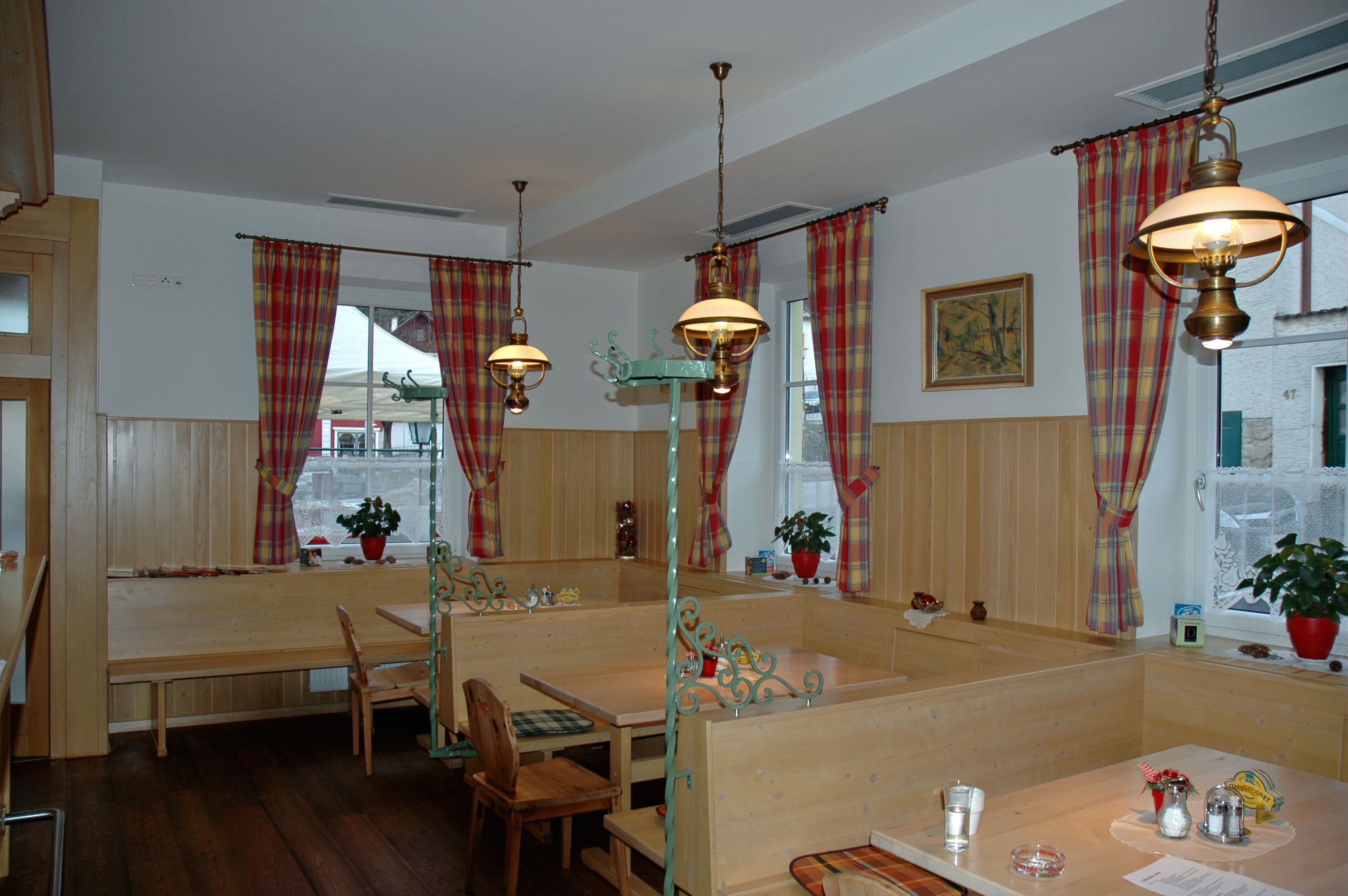 Útulná jedáleň s dreveným nábytkom a kockovanými závesmi.