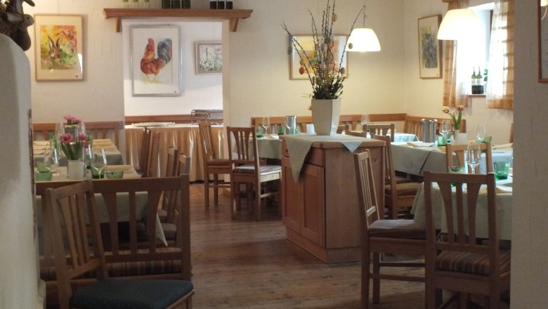 &Uacute;tuln&aacute; re&scaron;taur&aacute;cia s dreven&yacute;m n&aacute;bytkom, prestret&yacute;mi stolmi a v&aacute;zami s kvetmi. Obr&aacute;zky zvierat na sten&aacute;ch.