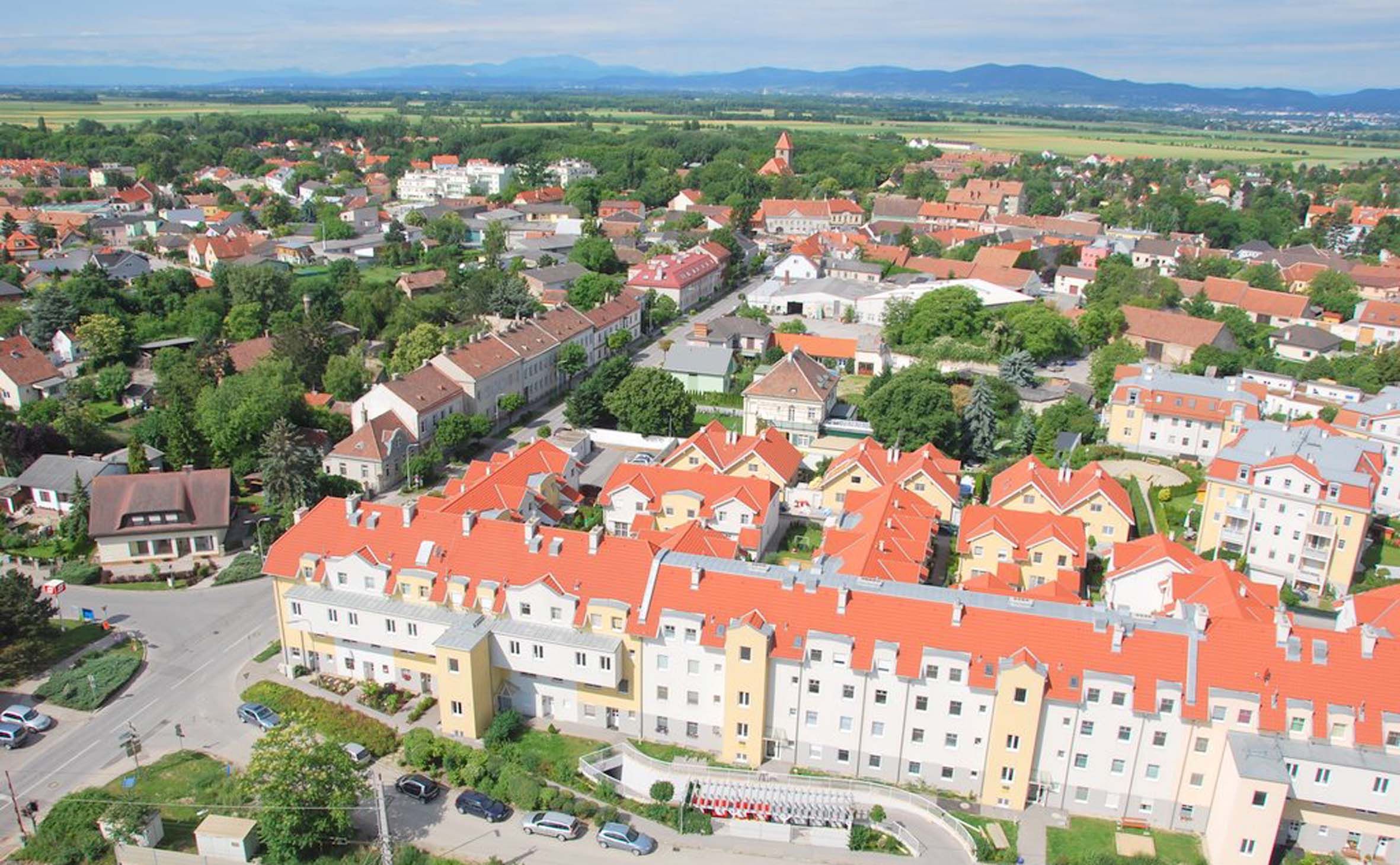 Letecký pohľad na Himberg s červenými strechami a zelenou krajinou.